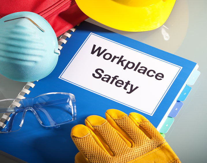 blue workplace safety book with yellow glove and hard hat